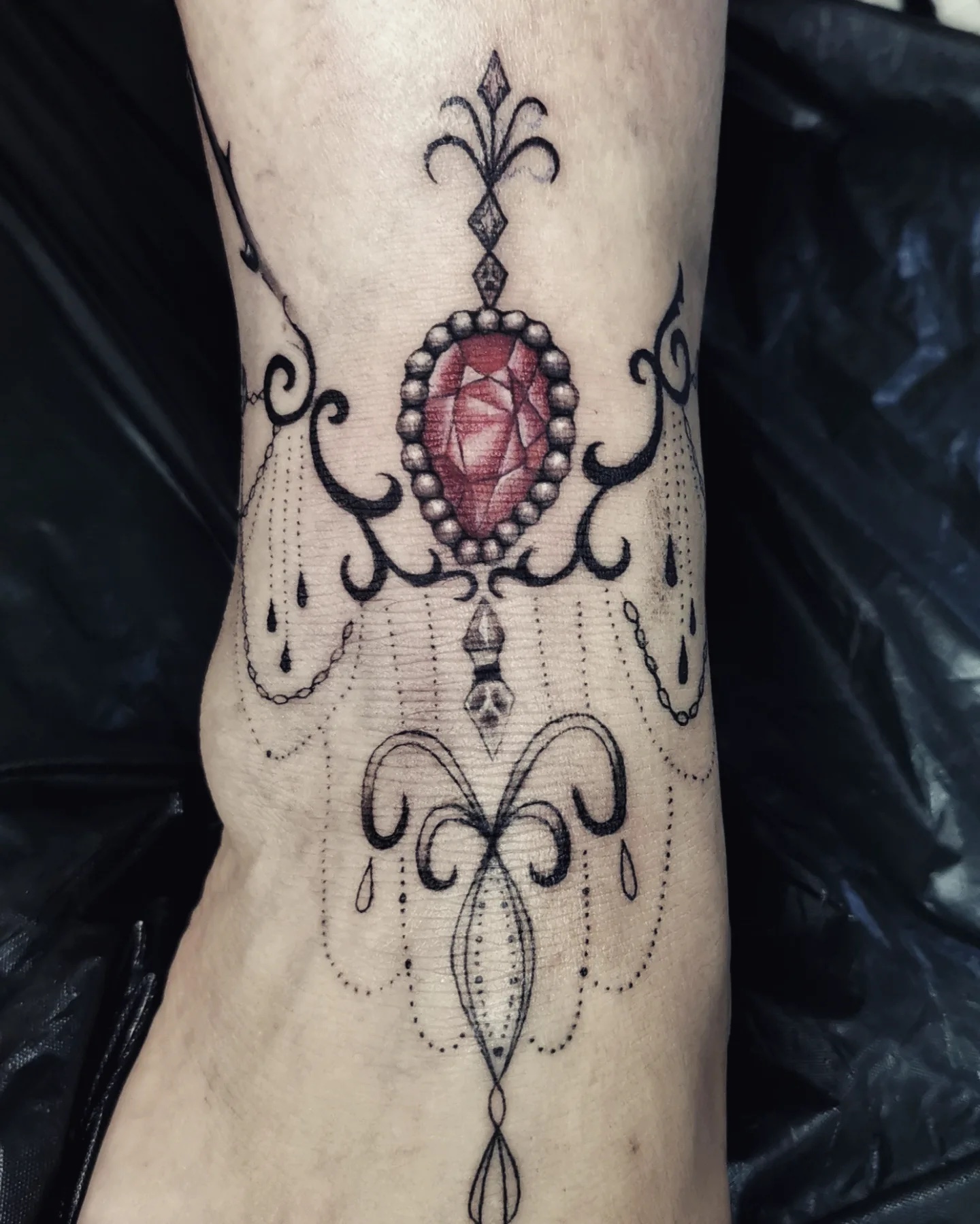 Ornamental jewel with red stone on the wrist
